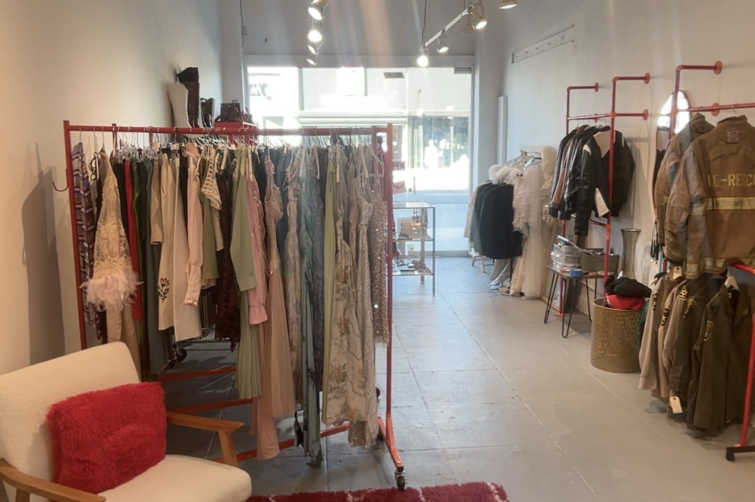 Finished studio: wall-mounted and rolling racks loaded with stock, seating and rug at the front