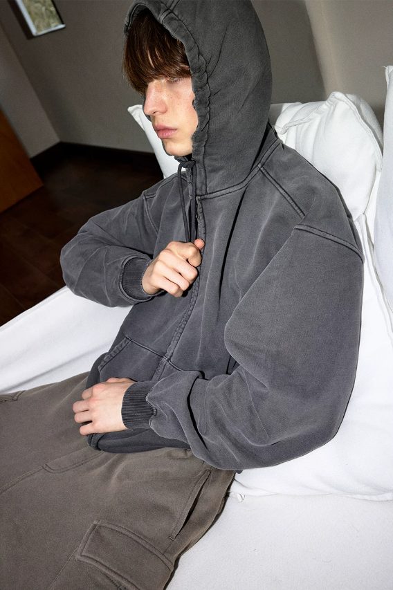 Graphite hoodie worn hooded, close on the zip and hood volume