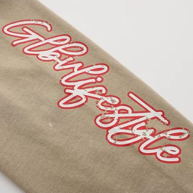 Macro of the red and white script print on the contrast sand sleeve