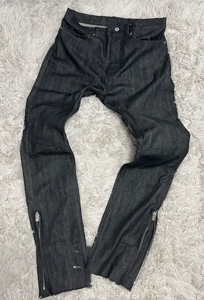 The finished jean laid flat, both outseam zips open at the ankle