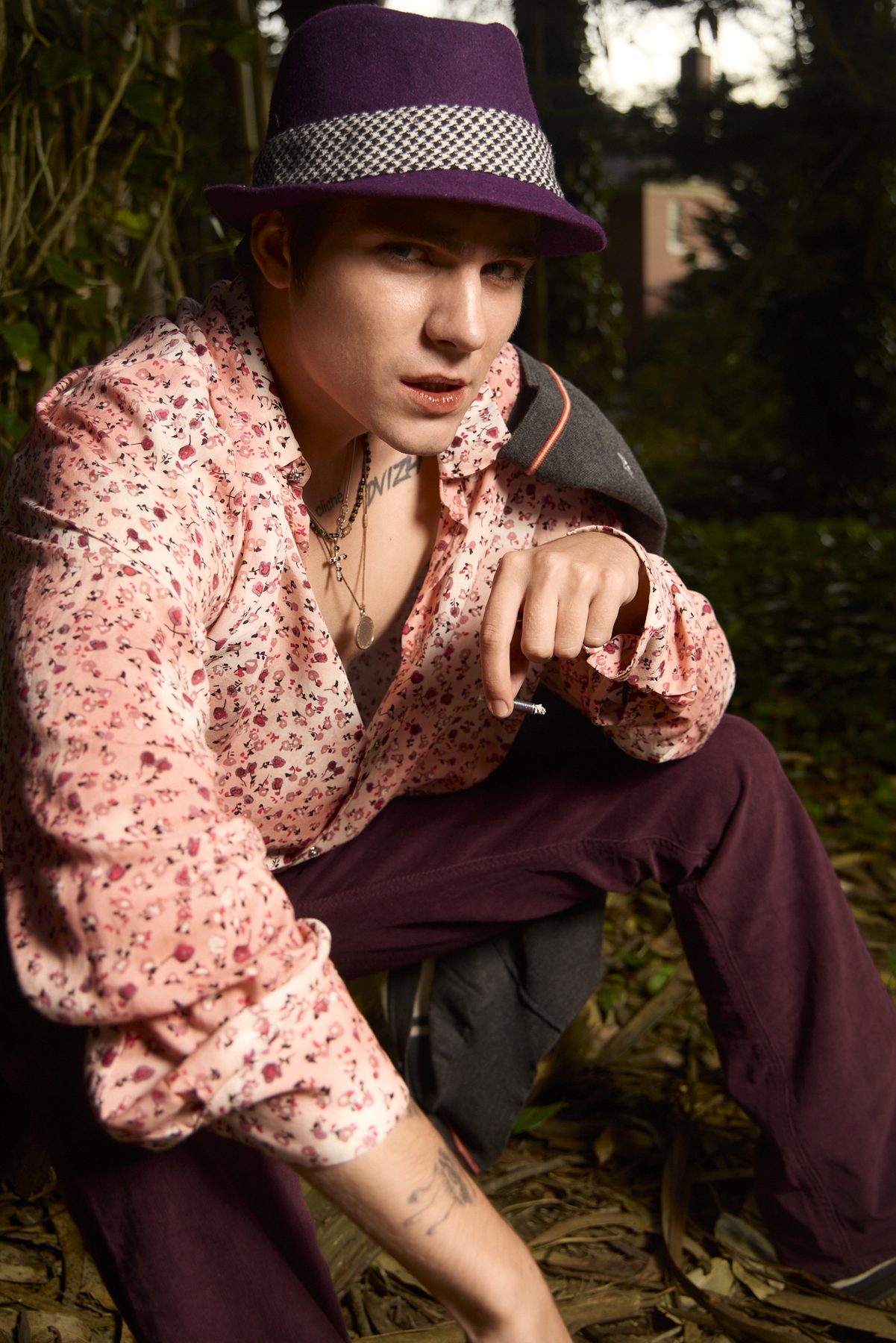 Crouched close-up, floral shirt sleeves rolled, cigarette in hand