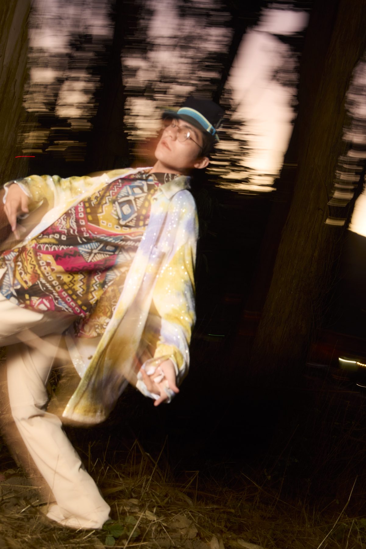 Model leaning back, trunks smeared by a dragged shutter, body frozen by flash